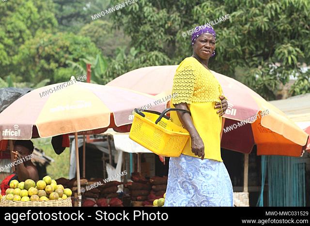 A portrait of a woman coming to shop for food at a market place. Sierra Leone