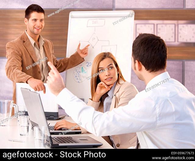 Happy young businesspeople having business training in meeting room