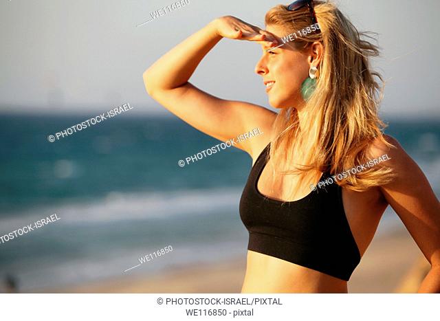 Young woman of 25 on the beach looking out to sea
