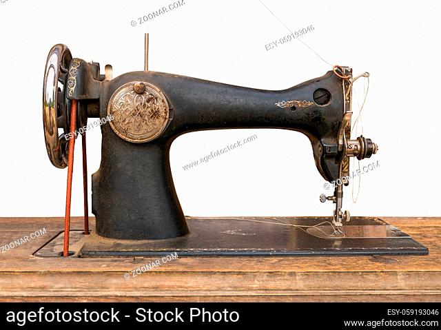 An Isolated Antique Sewing Machine On A Wooden Table With A White Background