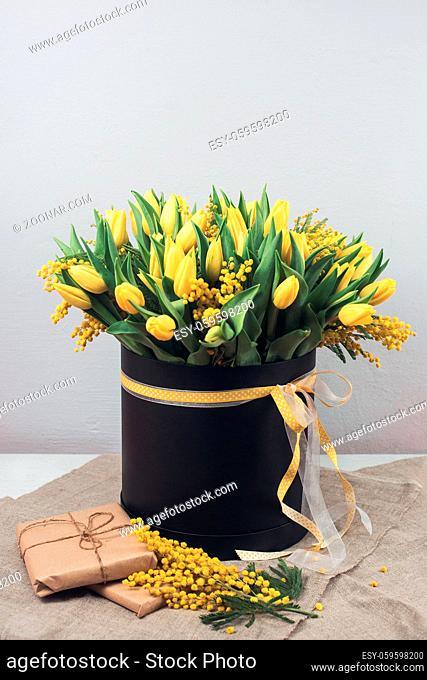 Bright spring bouquet of tulips and mimosa flowers. Mother's Day or Easter theme