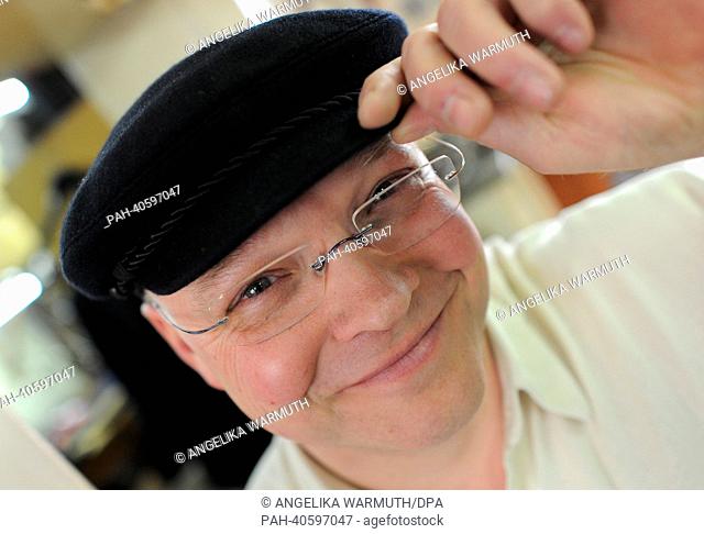 (FILE) An archive photo dated 15 March 2013 shows cap maker Lars Kuentzel smiles in his store in Hamburg,  Germany. Since 1892, the caps Altona