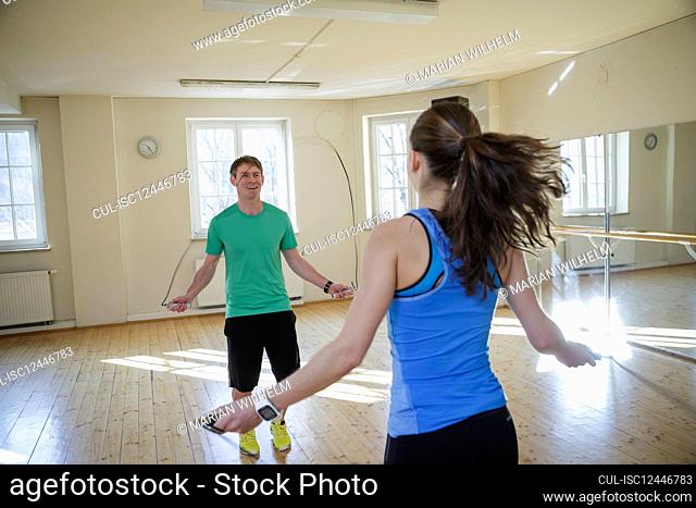 Gym workout with personal trainer using jump rope
