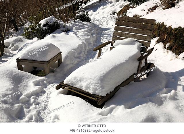 DEUTSCHLAND, PLETTENBERG, 17.02.2010, nature, seasons, winter, snow, freetime, relaxation, deckchair and wooden table in a garden snow-covered - Plettenberg