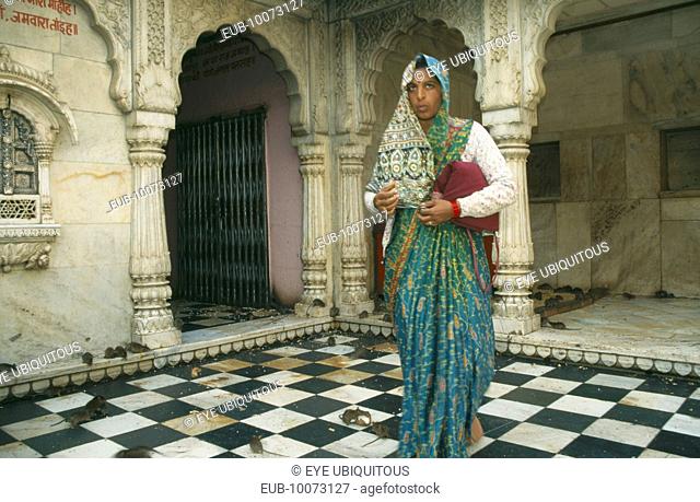 Interior of Karni Mata Temple near Bikaner with woman worshipper in tradtional dress feeding the rats that inhabit the temple