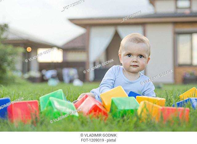 Baby in the garden with building blocks