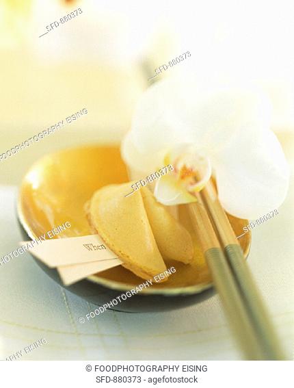 Asian table setting with fortune cookie and orchid