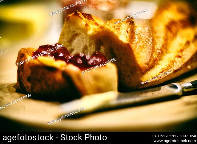 02 December 2022, Lower Saxony, Brunswick: Strawberry jam lies on a toasted slice of a baguette. The UN cultural organization Unesco has recognized the baguette...