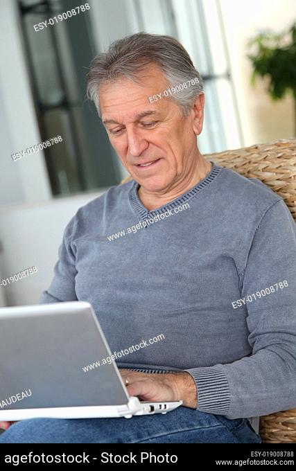 Senior man surfing on internet at home