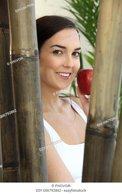 Woman eating a red apple at a spa