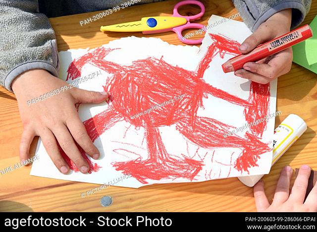 02 June 2020, Saxony, Leipzig: A child from the Leipzig book kindergarten paints a corona virus at the Scheibenholz racecourse