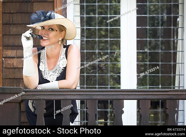 Attractive young woman in twenties outfit on porch of an antique house