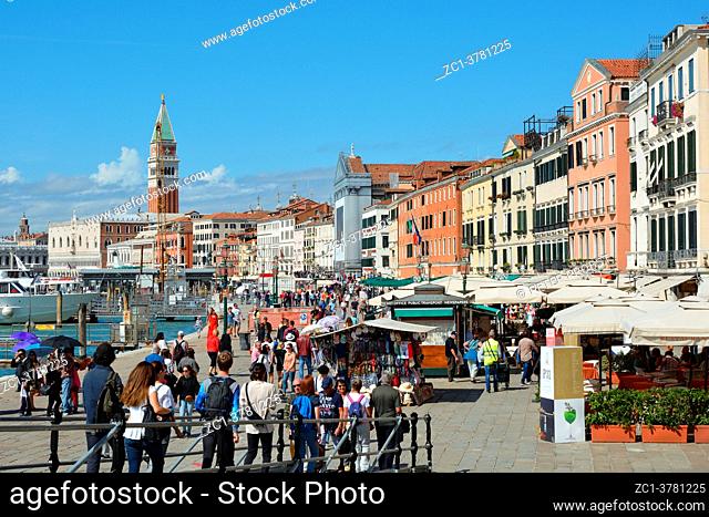 Waterfront Riva degli Schiavoni with tourists at the Campanile of San Marco in Venice - Italy