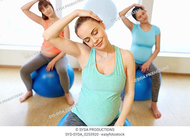 pregnant women training with exercise balls in gym