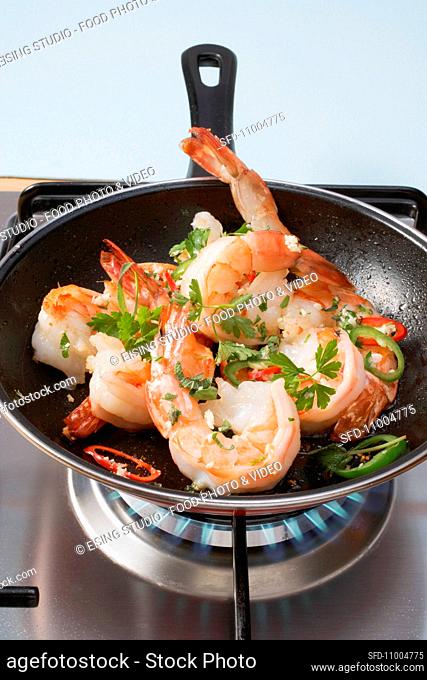 Prawns being mixed with herbs and chilis