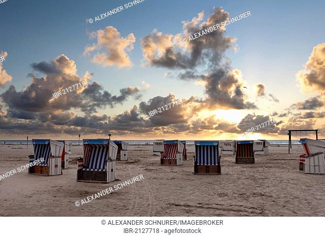 Roofed wicker beach chairs on the beach of Sankt Peter-Ording at sunset, North Friesland district, Schleswig-Holstein, Germany, Europe