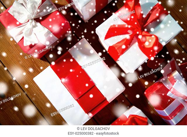 christmas, holidays, presents, new year and celebration concept - close up of gift boxes and red balls on wooden floor from top