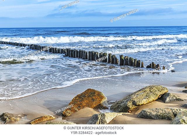 Beach with stones and old groynes on the Baltic Sea. Groynes are intended to break the shaft and to prevent the erosion of the coast