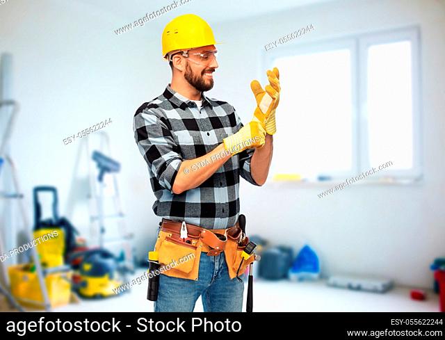 happy male worker or builder in helmet and gloves