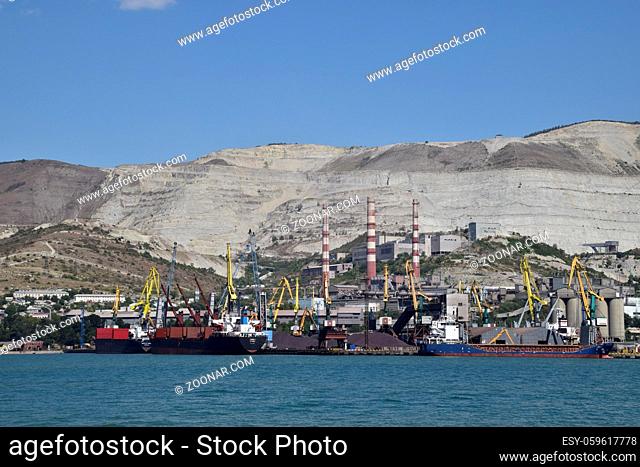 international seaports. Cargo port with port cranes. Sea bay and mountainous coast