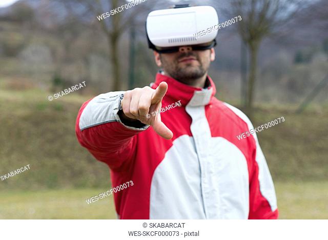 Man playing with Virtual Reality Glasses in nature