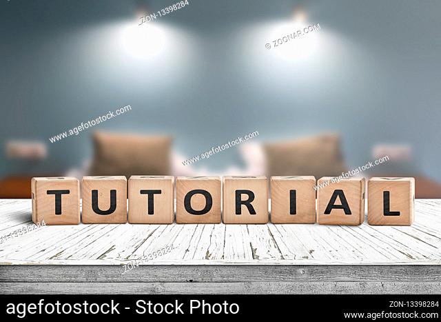Tutorial sign on a wooden table in a room with lights on a blurry background