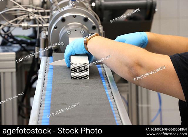 16 September 2021, Thuringia, Hermsdorf: An employee works on the production of aluminum oxide honeycombs at the opening of the pilot center for powder...