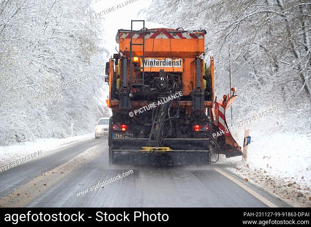 dpatop - 27 November 2023, Rhineland-Palatinate, Idenheim: A winter road clearance vehicle clears snow from the L2 and spreads salt