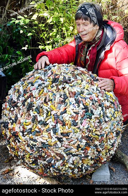 02 October 2021, Saxony, Leipzig: Ingrid Hund is standing in ""her"" Hundtsche Park by a sphere from the GDR era consisting of several hundred plastic animals
