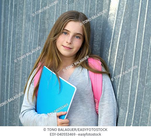 Blond kid student girl back to school with notebook and backpack in the city
