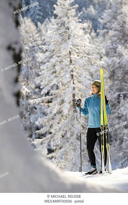 Austria, Tyrol, Seefeld, Wildmoosalm, Woman holding cross-country skis