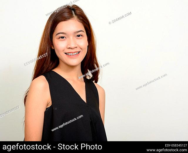 Studio shot of young beautiful Asian woman against white background