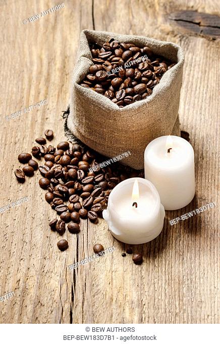 Jute sack of coffee beans on wooden table, copy space