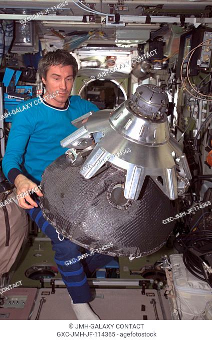 Cosmonaut Sergei K. Krikalev, Expedition 11 commander representing Russia's Federal Space Agency, holds the dismantled probe-and-cone docking mechanism from the...