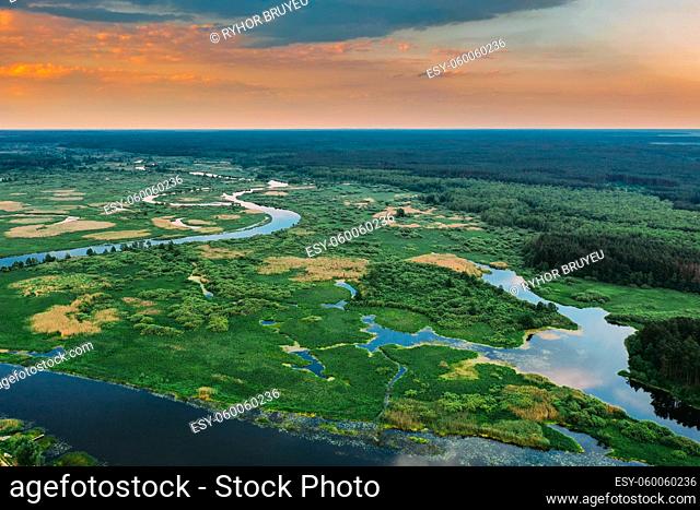 Aerial View. Sunset Sky Above Green Forest, Meadow And River Landscape In Sunny Evening. Top View Of European Nature From High Attitude In Summer Sunrise