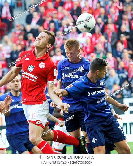Mainz's Gaetan Bussmann (l) trying a header in Darmstadt's penalty box, pressured by Darmstadt's Roman Bezjak (M) and Laszlo Kleinheisler (r)during the match...