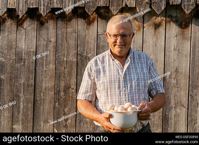 Senior man with bowl of eggs