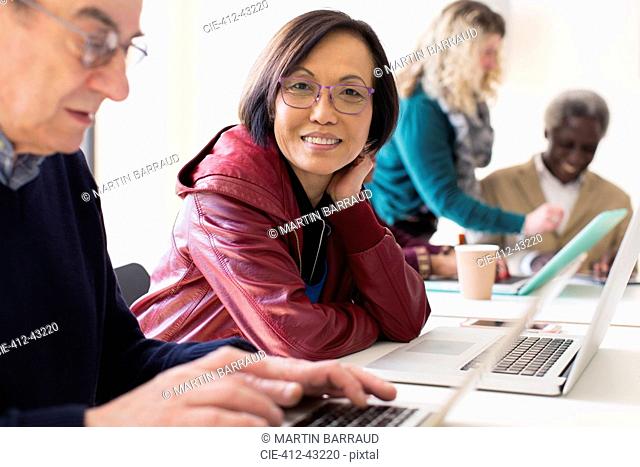 Portrait smiling, confident senior businesswoman using laptop in conference room meeting