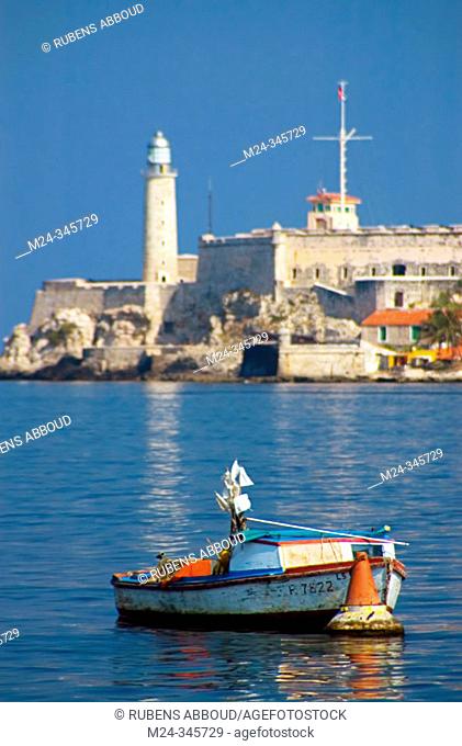 Fishing boat anchored at Havana Harbour with the Castillo de los Tres Reyes del Morro in the background. Havana, Cuba