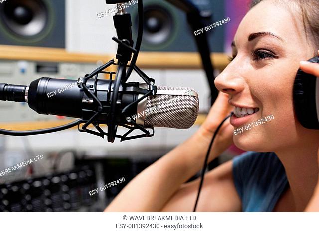 Close up of a young radio host speaking through a microphone