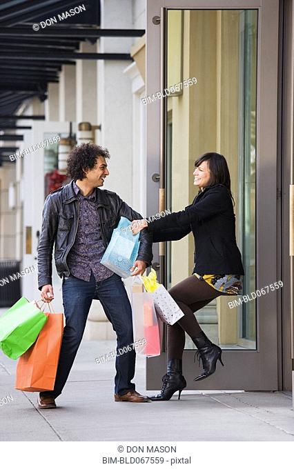 Woman pulling boyfriend into store