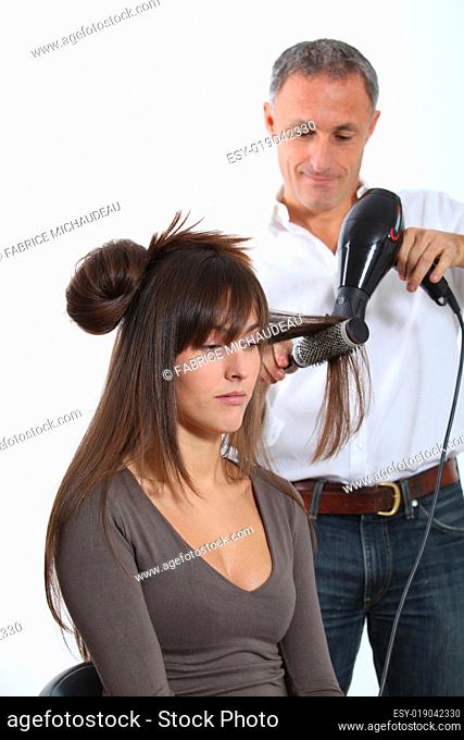 Hairdresser drying woman's hair