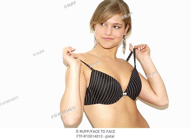 Blond woman is pulling her strapped bra