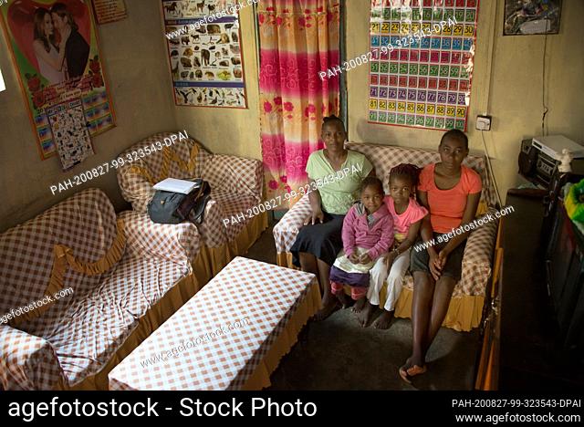 06 August 2020, Kenya, Nairobi: Hannah Mburu (l) sits with her daughters Mary (r), Joy (2nd from right) and Dorkas on the family sofa in their house in the slum...