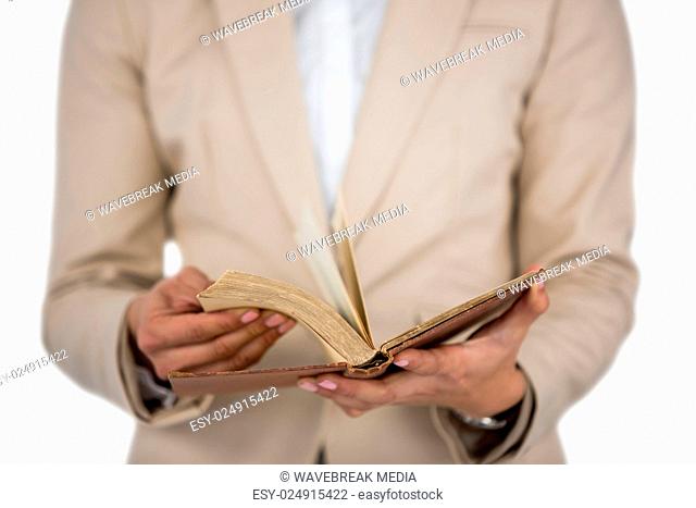 Mid section of Businesswoman flips through the pages of a book