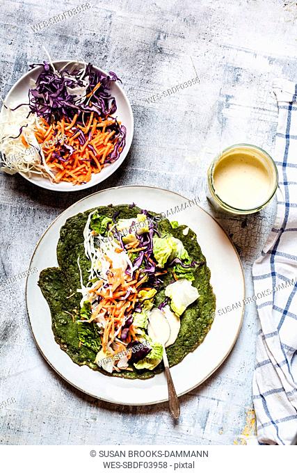 Lettuce wrap with spinach tortillas filled with lettuce, carrots and salad dressing