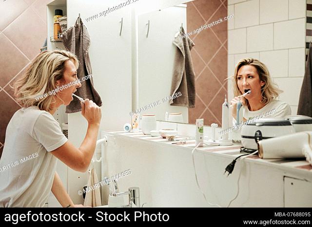 Woman brushing teeth in the bathroom