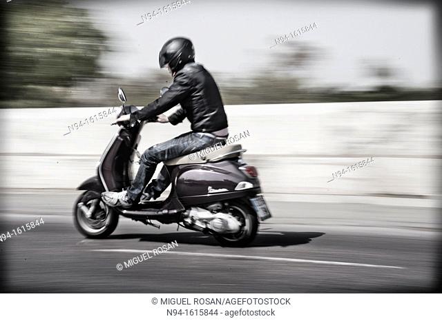 Man with motorcycle, speed circulating around town