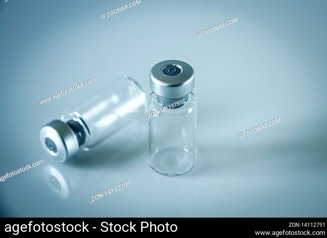 two vaccine glass bottles on grey background