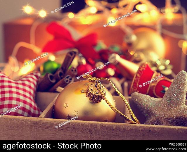 Colorful Christmas decoration items in a wooden box, close up with the selective focus on foreground
